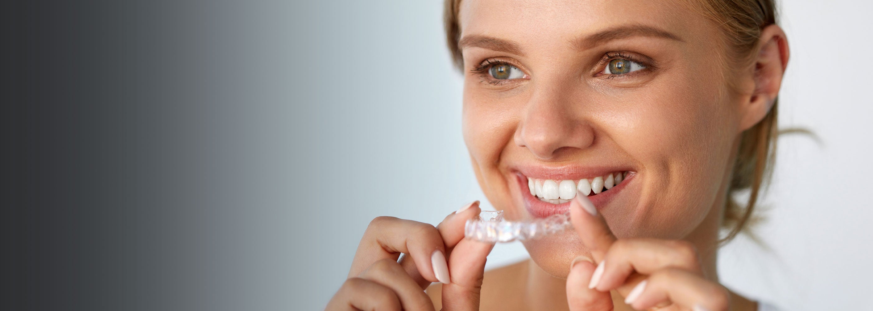 Orthodontic patient holding clear aligner