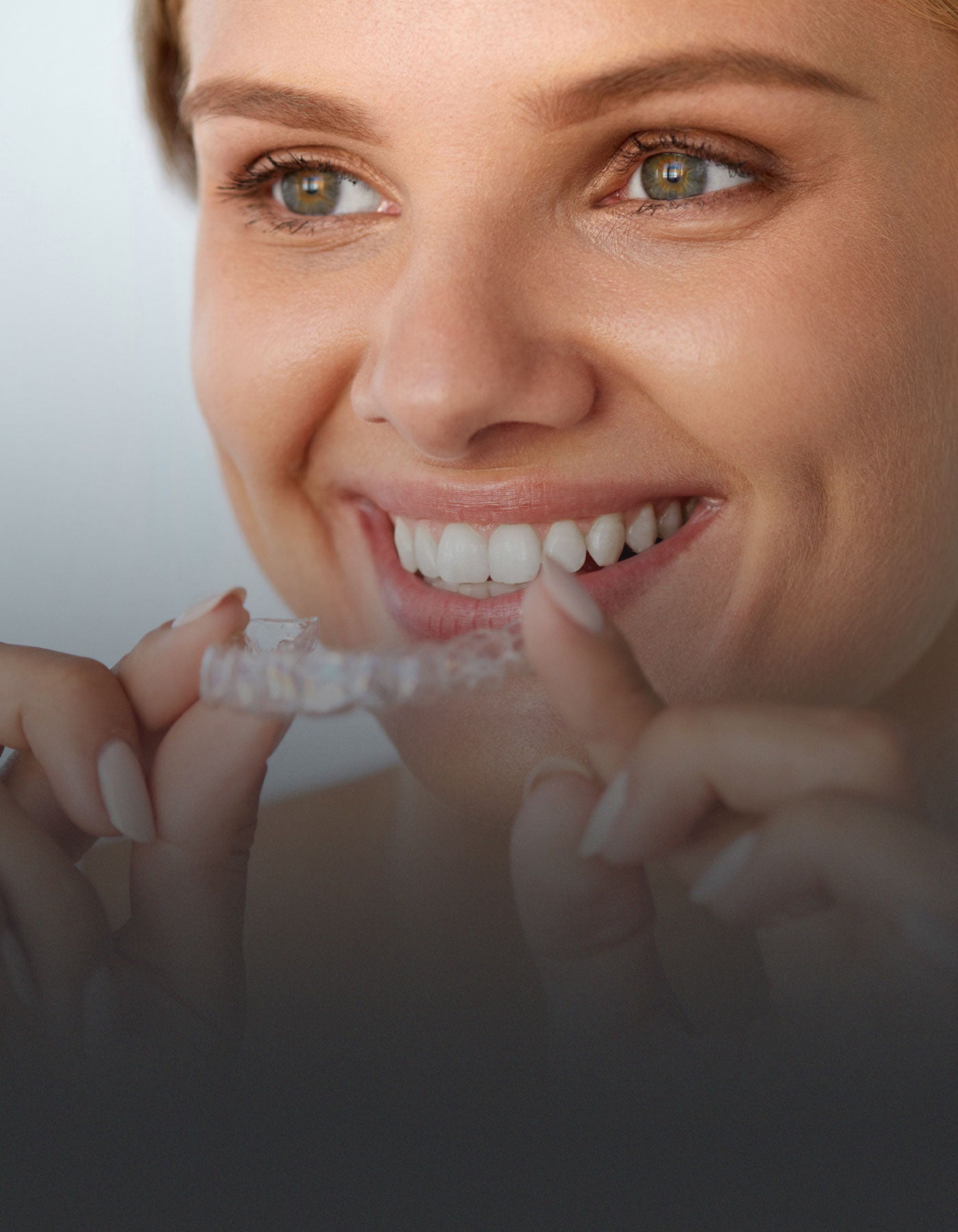 Patient holding orthodontic aligners for straight teeth